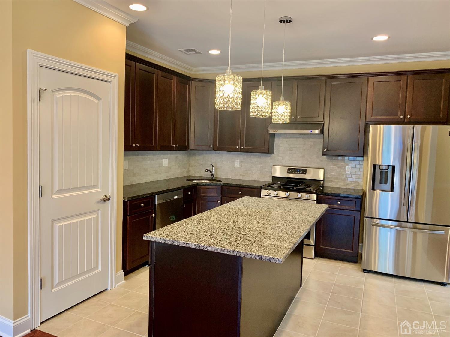 144 Harding Avenue, Unit 2 Edison, NJ 08820 - Photo 9 of 12 a kitchen with a refrigerator a sink and a stove top oven with wooden floor