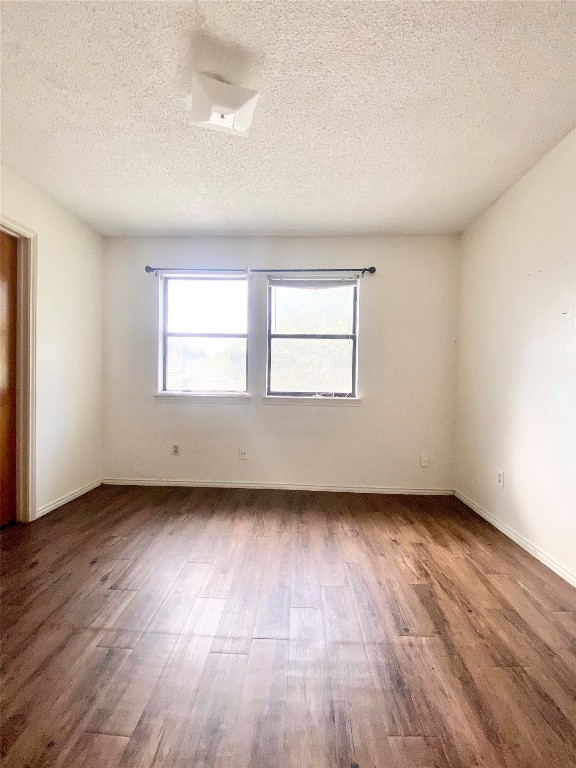 7808 Topawa Cove, Unit B Austin, TX 78729 - Photo 6 of 10 an empty room with wooden floor and windows