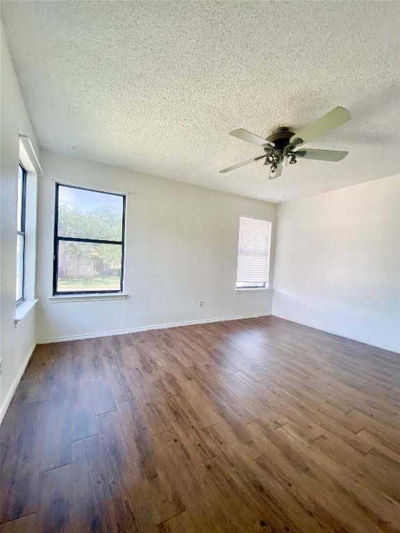 7808 Topawa Cove, Unit B Austin, TX 78729 - Photo 8 of 10 an empty room with wooden floor and windows