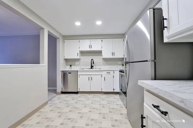 a kitchen with white cabinets and appliances