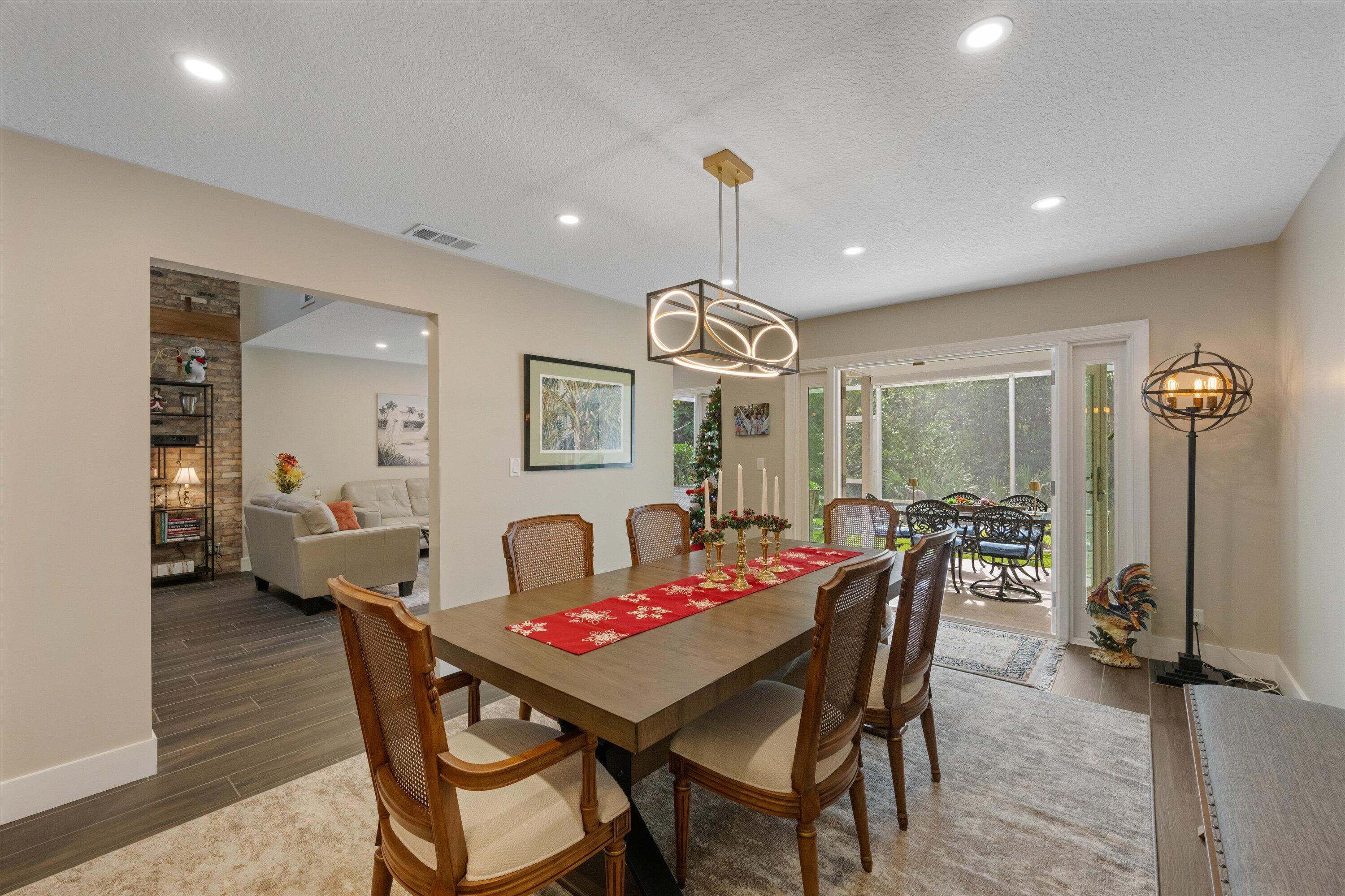 8878 Southeast Riverfront Terrace Jupiter, FL 33469 - Photo 13 of 57 a dining room with furniture a rug and a chandelier
