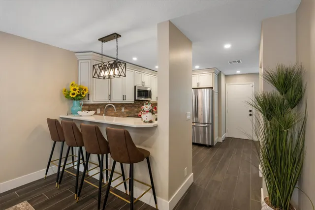 a kitchen with a sink dishwasher a stove and a microwave oven with wooden floor