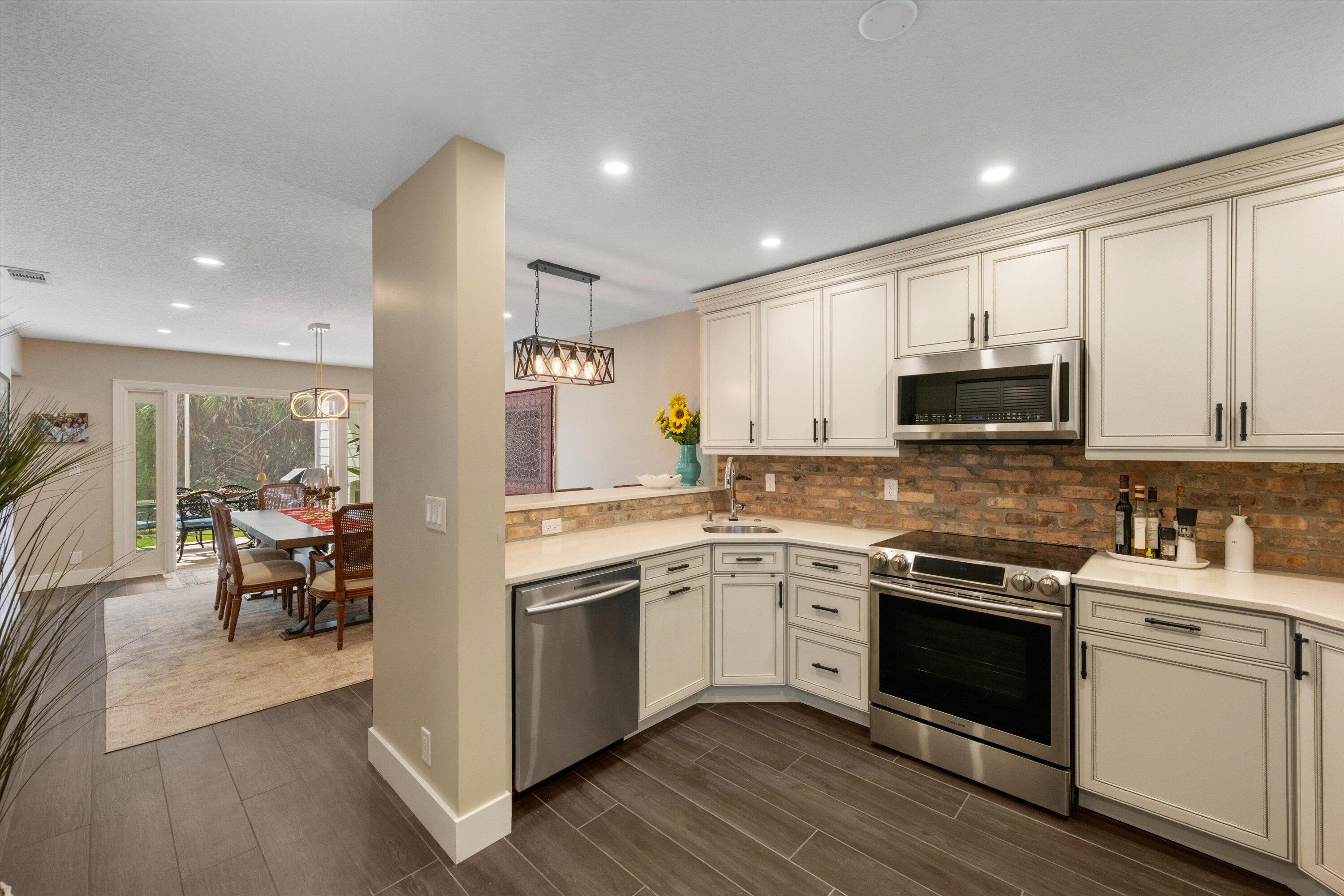 8878 Southeast Riverfront Terrace Jupiter, FL 33469 - Photo 16 of 57 a kitchen with a sink cabinets and wooden floor