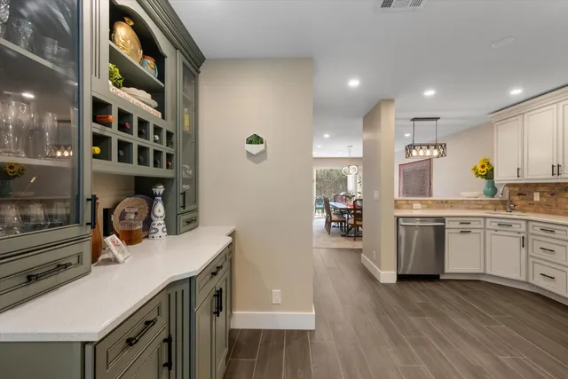 a kitchen with a sink stainless steel appliances and white cabinets