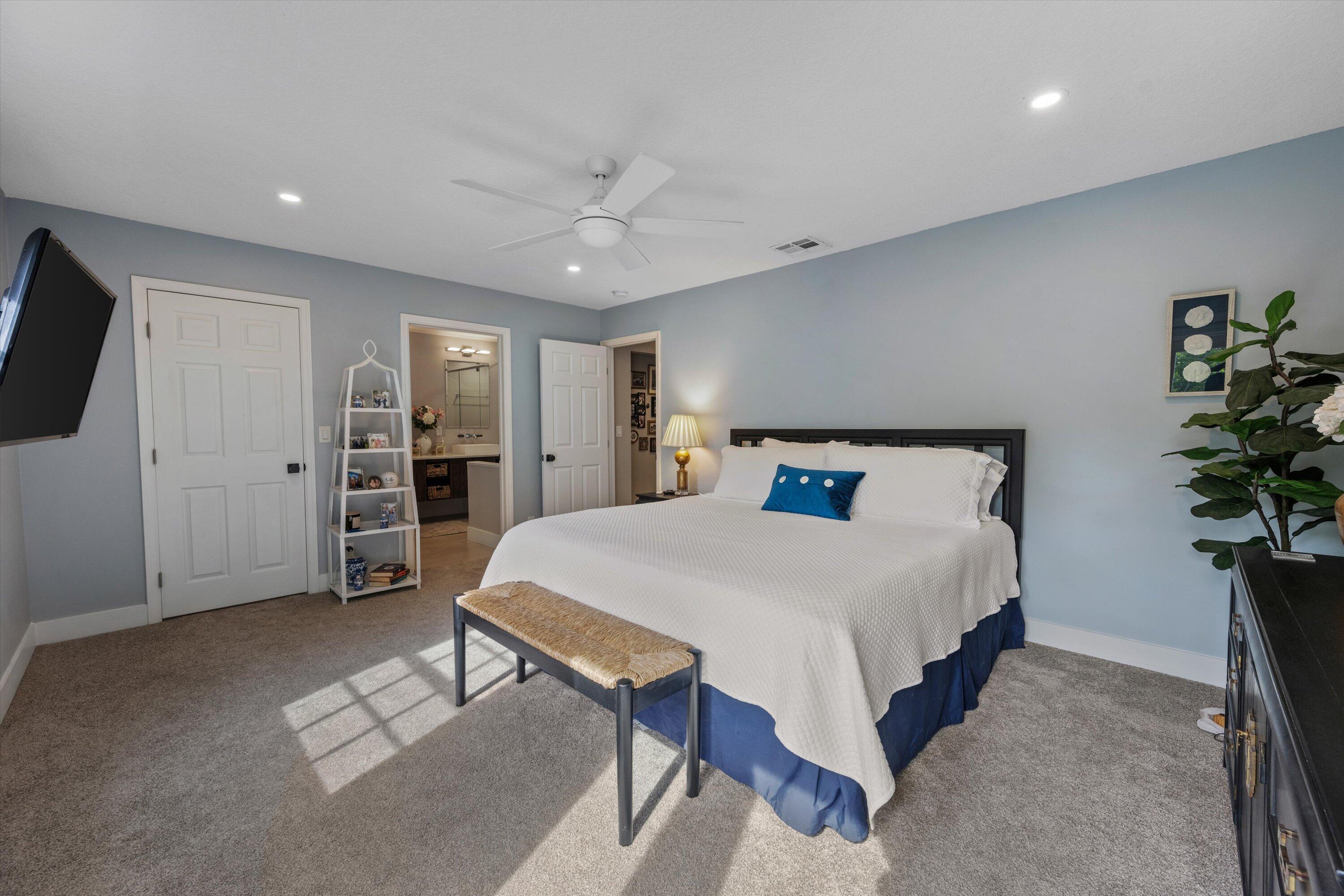 8878 Southeast Riverfront Terrace Jupiter, FL 33469 - Photo 24 of 57 a spacious bedroom with a bed and a flat screen tv