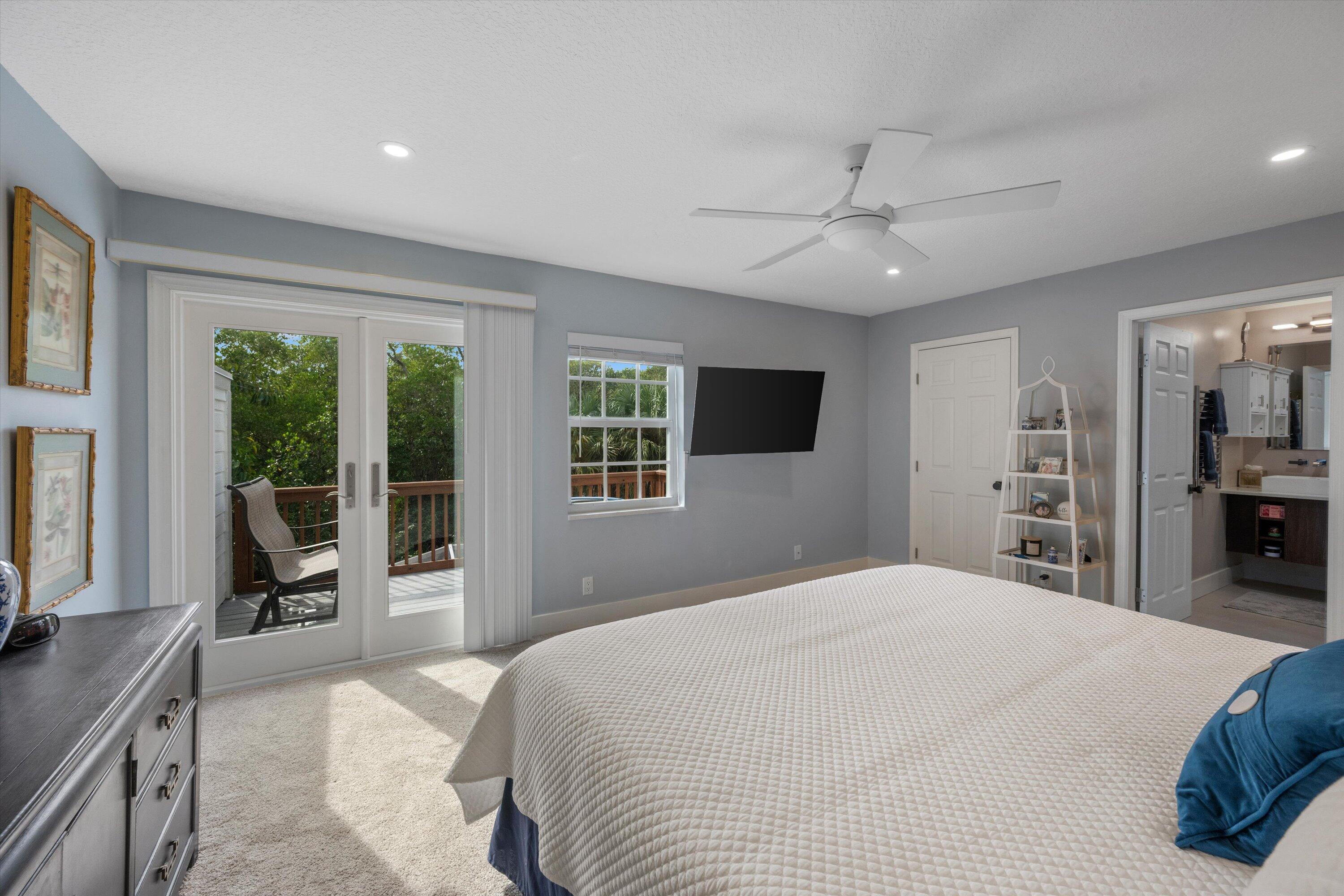 8878 Southeast Riverfront Terrace Jupiter, FL 33469 - Photo 25 of 57 a bedroom with a large bed and a flat tv screen