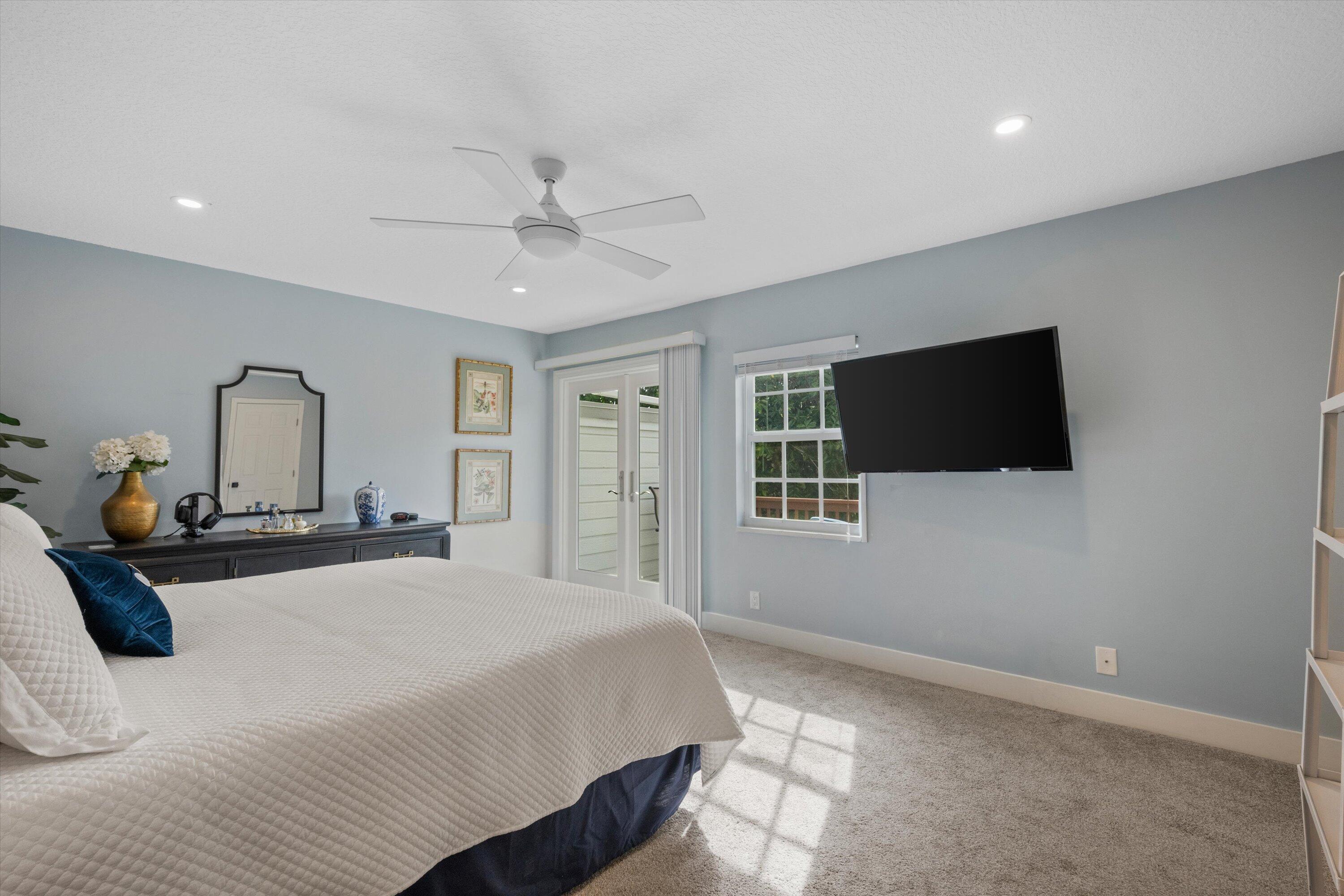 8878 Southeast Riverfront Terrace Jupiter, FL 33469 - Photo 26 of 57 a bedroom with a bed and a flat screen tv