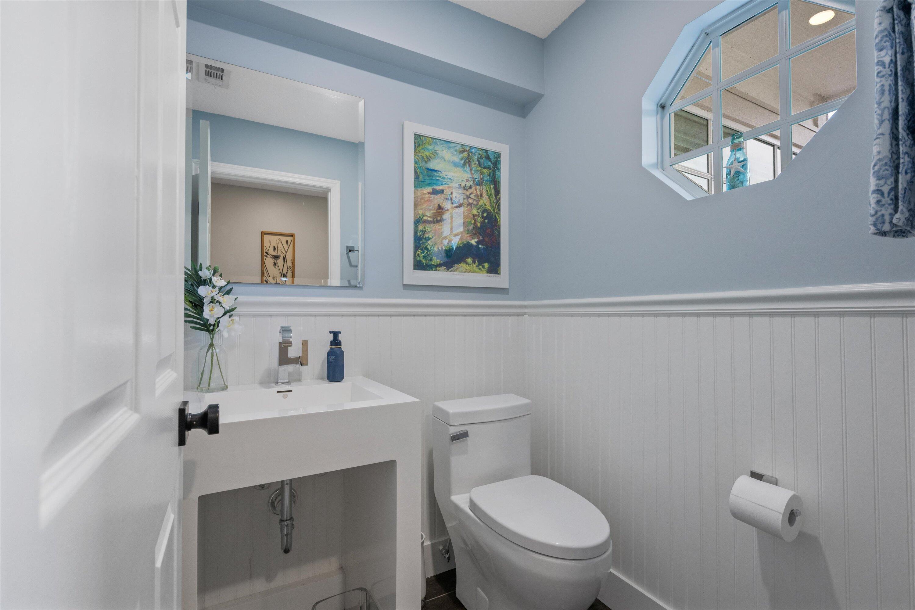 8878 Southeast Riverfront Terrace Jupiter, FL 33469 - Photo 32 of 57 a bathroom with a toilet a sink and mirror