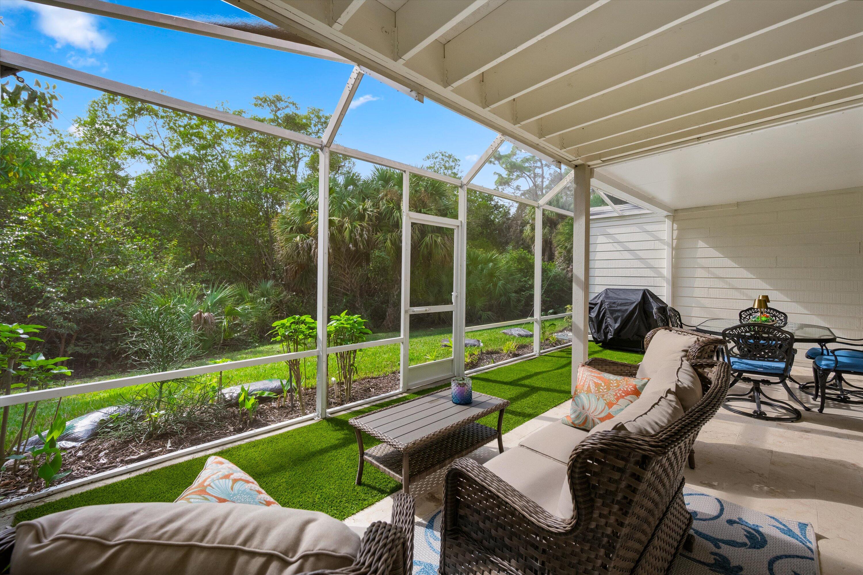 8878 Southeast Riverfront Terrace Jupiter, FL 33469 - Photo 39 of 57 a view of a patio with a table chairs and a backyard