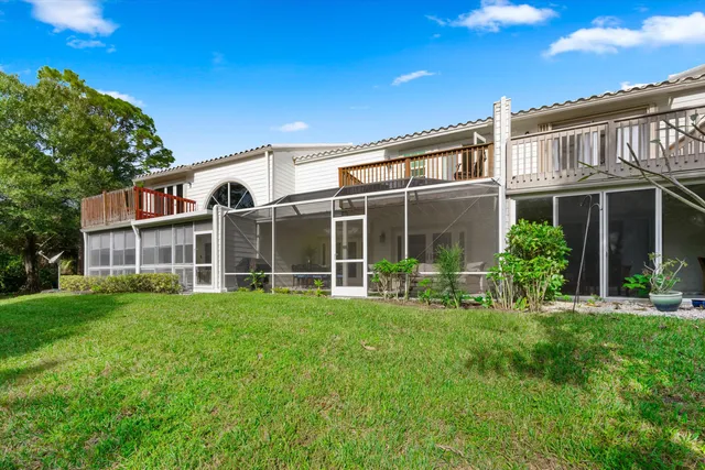 an aerial view of a house with outdoor space and lake view in back