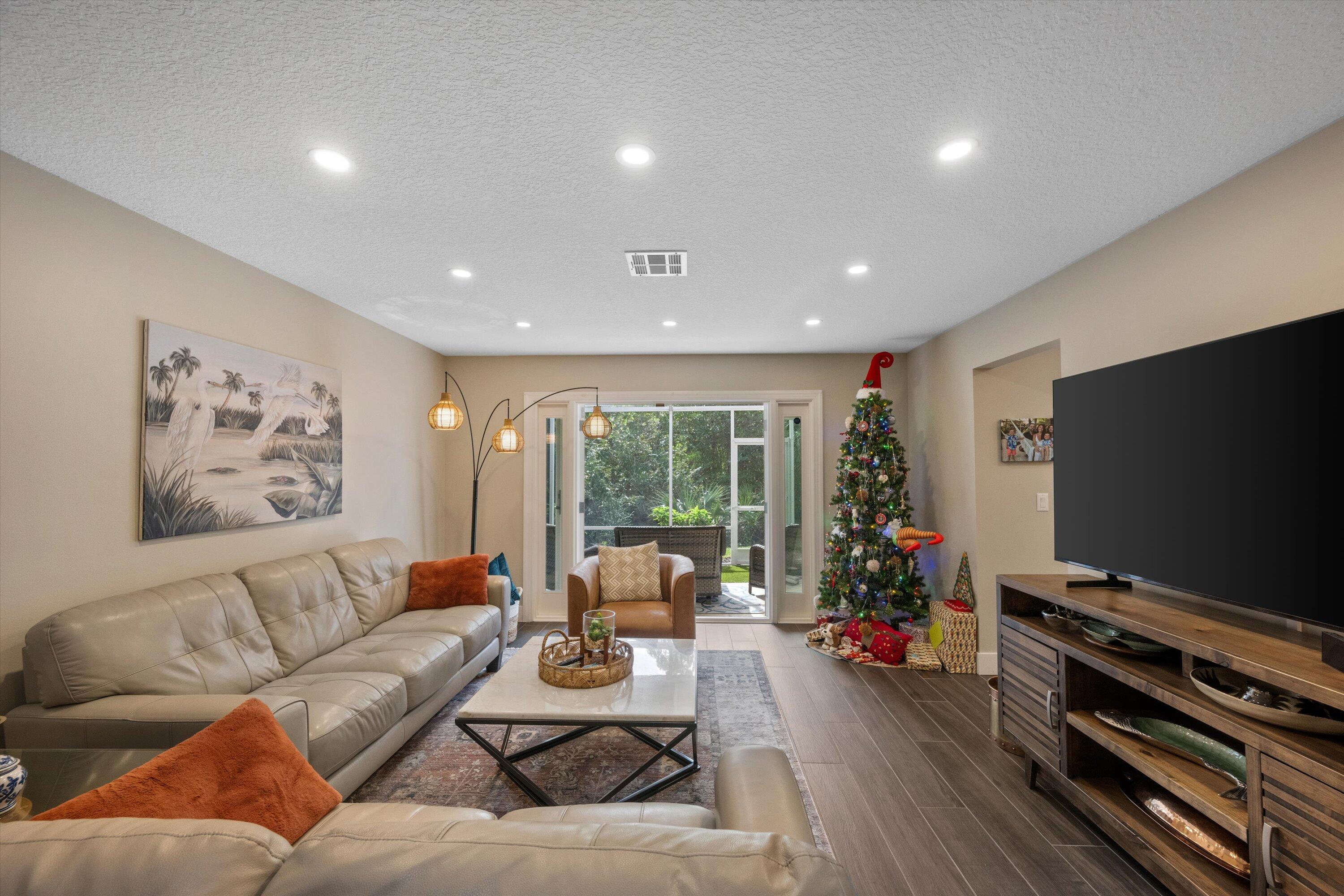 8878 Southeast Riverfront Terrace Jupiter, FL 33469 - Photo 9 of 57 a living room with furniture and a flat screen tv