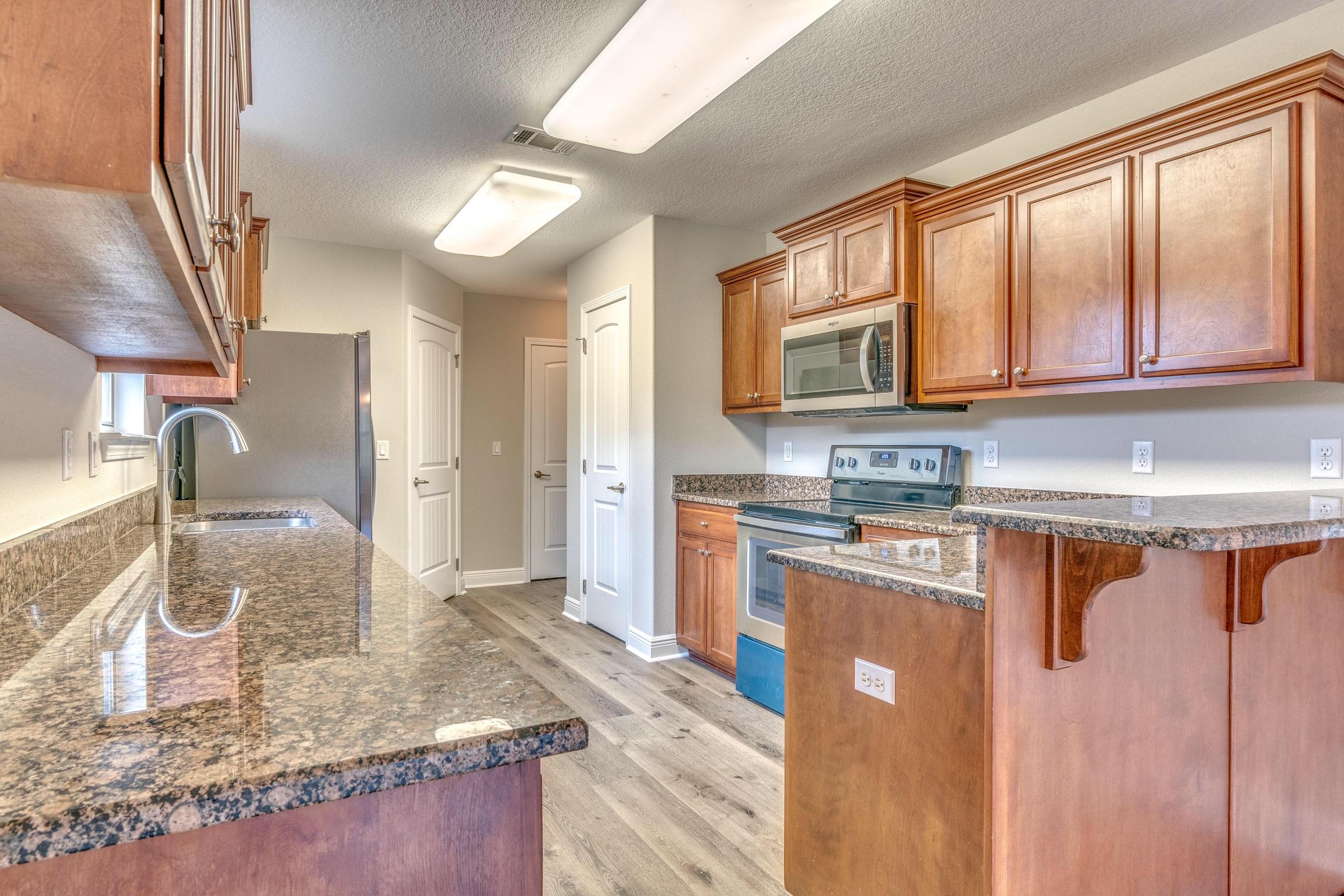 129 Bronze Circle Crestview, FL 32539 - Photo 12 of 31 a kitchen with stainless steel appliances granite countertop a stove a sink and a microwave
