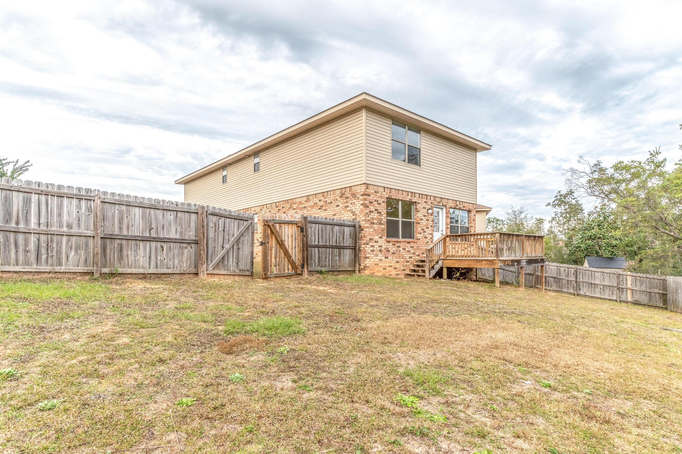 129 Bronze Circle Crestview, FL 32539 - Photo 29 of 31 a view of an house with backyard and trees in the background