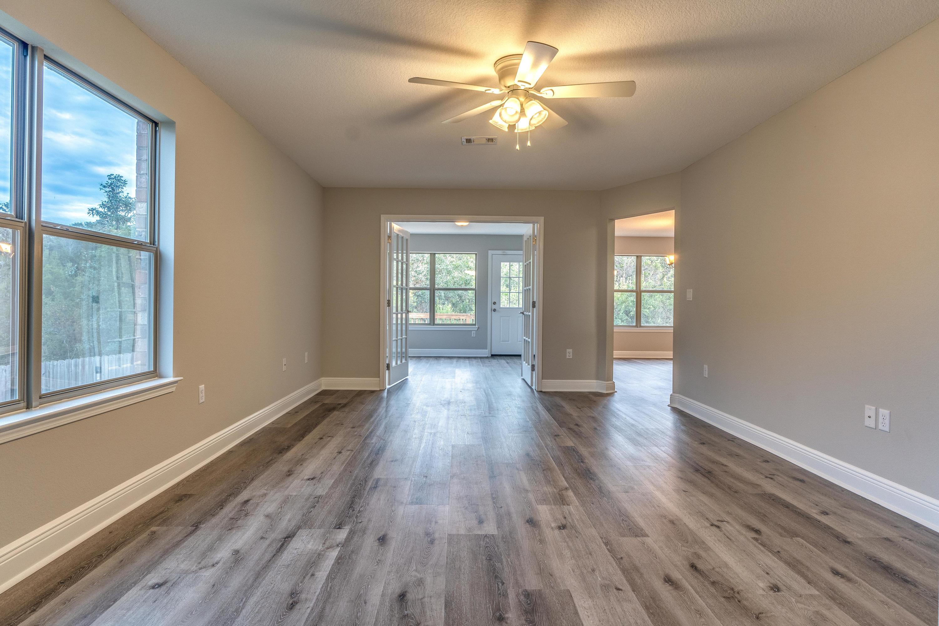 129 Bronze Circle Crestview, FL 32539 - Photo 5 of 31 an empty room with wooden floor and windows