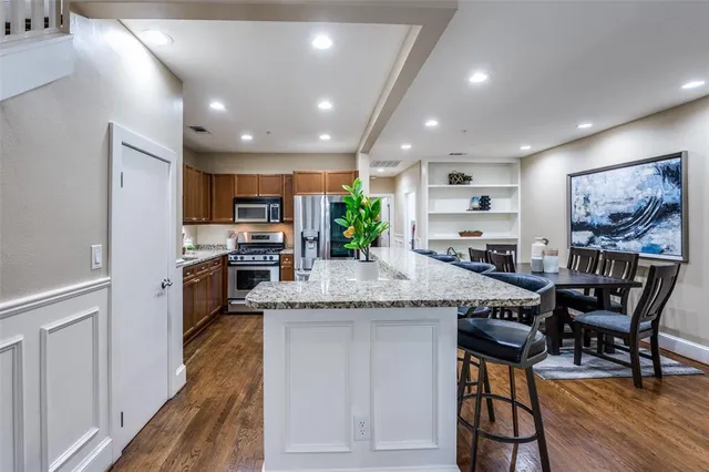 a kitchen with stainless steel appliances kitchen island granite countertop a stove and a refrigerator