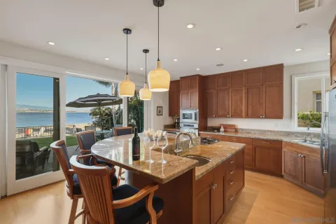 a kitchen with stainless steel appliances granite countertop a sink a stove and a wooden floors