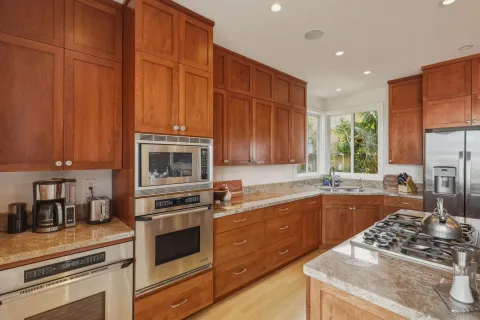a kitchen with stainless steel appliances granite countertop a stove a sink and a microwave