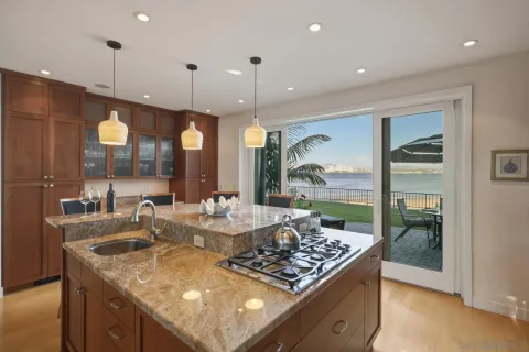 a kitchen with a stove a sink a refrigerator and chairs