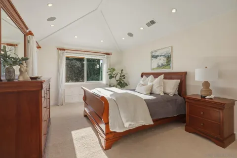 a spacious bedroom with a bed and a dresser
