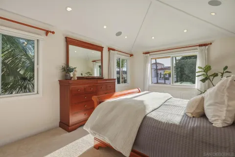 a bedroom with a large bed and large windows