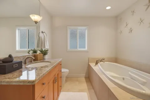 a bathroom with a granite countertop sink a toilet and bathtub
