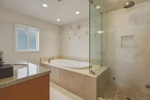 a bathroom with a granite countertop sink a mirror and a shower