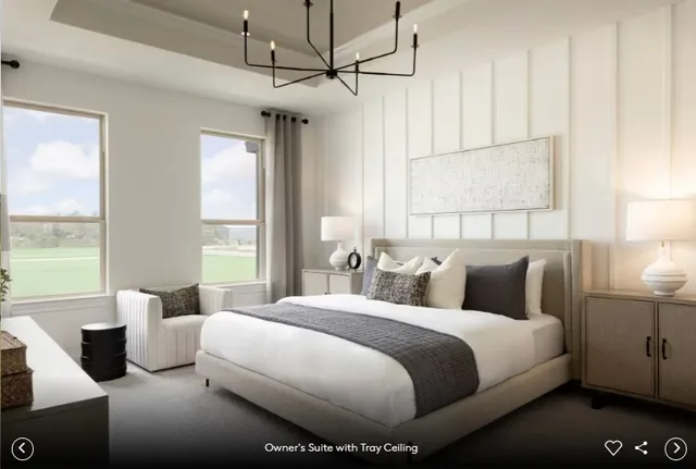 a bedroom with a large bed and a chandelier