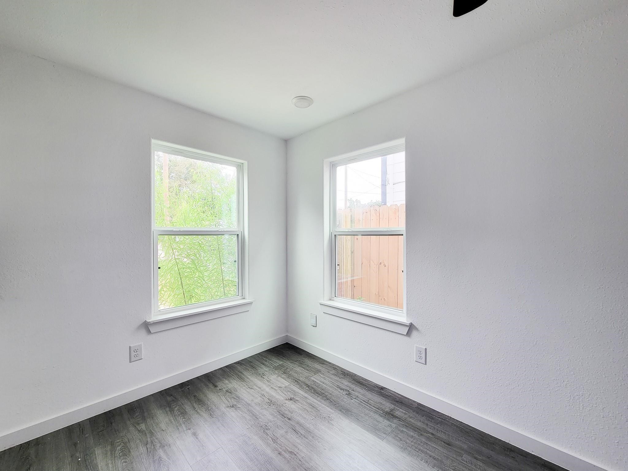 8122 Sterlingshire Street, Unit B Houston, TX 77078 - Photo 12 of 27 an empty room with wooden floor and windows