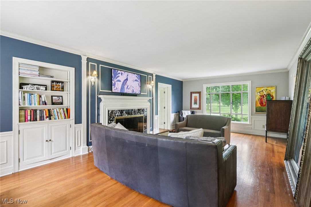 75 North Wheaton Road Akron, OH 44313 - Photo 5 of 40 Living area featuring a fireplace, crown molding, wood finished floors, a decorative wall, and built in shelves