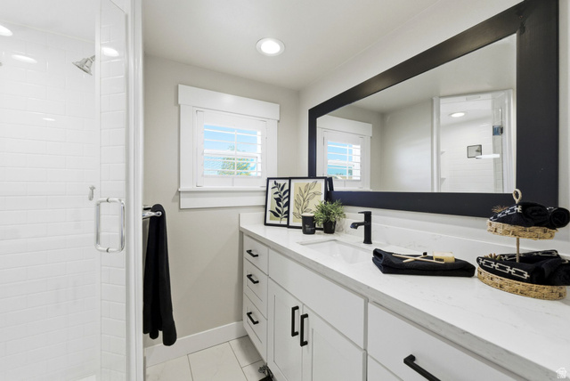 1405 Vintry Lane Murray, UT 84121 - Photo 18 of 44 Spacious vanity with a white countertop and undermount sink, complemented by a large framed mirror and black fixtures