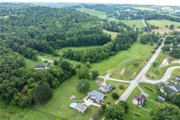 an aerial view of residential houses with outdoor space and trees