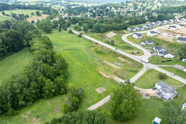 an aerial view of residential houses with outdoor space and trees