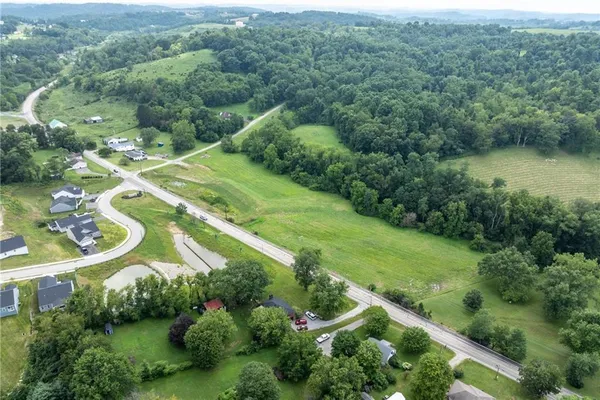 an aerial view of residential houses with outdoor space and trees