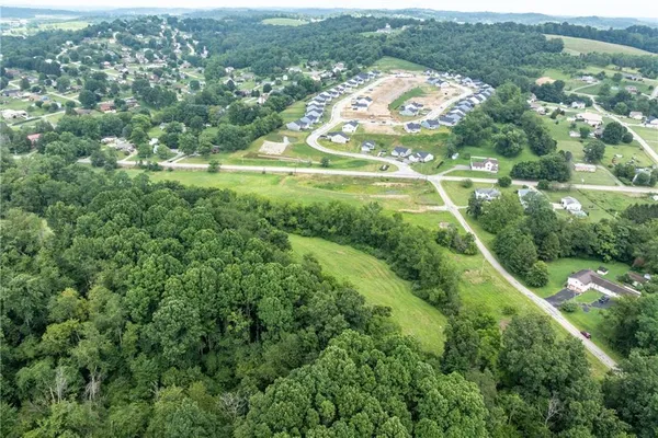 an aerial view of residential houses with outdoor space and trees