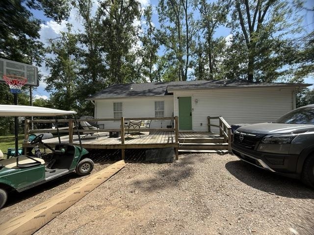 395 Austin Street Savannah, TN 38372 - Photo 26 of 32 Exterior featuring white horizontal siding, a dark shingle roof, and a prominent wooden deck