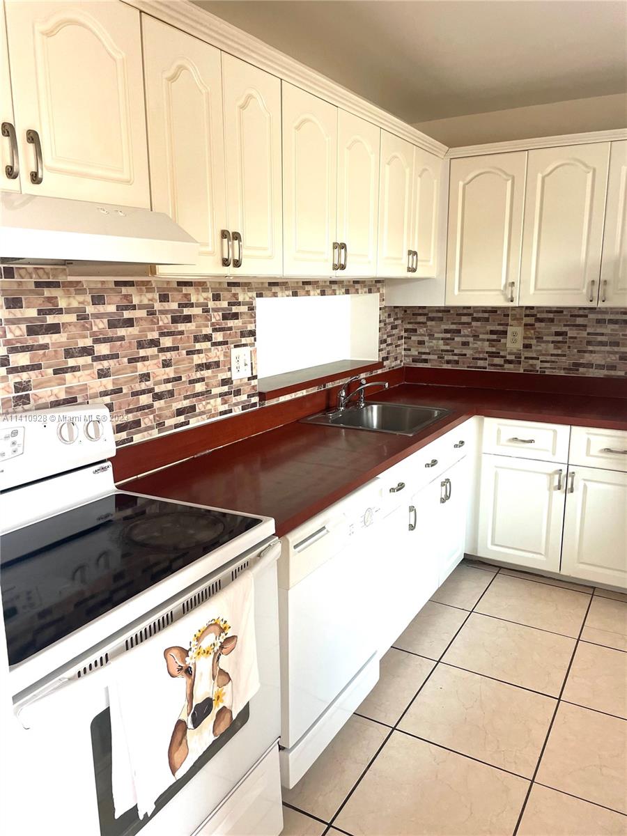 8600 Southwest 133rd Avenue Road, Unit 416 Miami, FL 33183 - Photo 4 of 23 a kitchen with granite countertop a sink and a stove