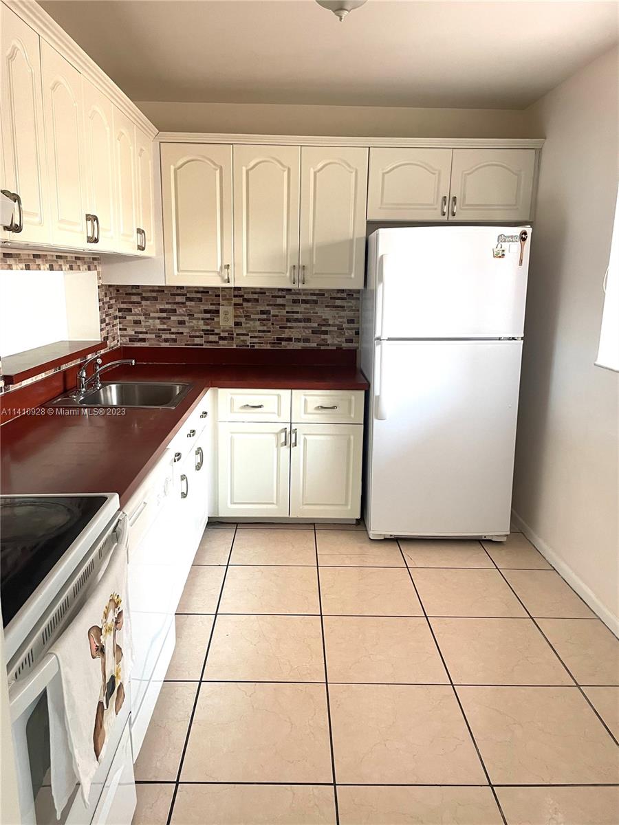 8600 Southwest 133rd Avenue Road, Unit 416 Miami, FL 33183 - Photo 5 of 23 a kitchen with a refrigerator a stove a microwave and cabinets