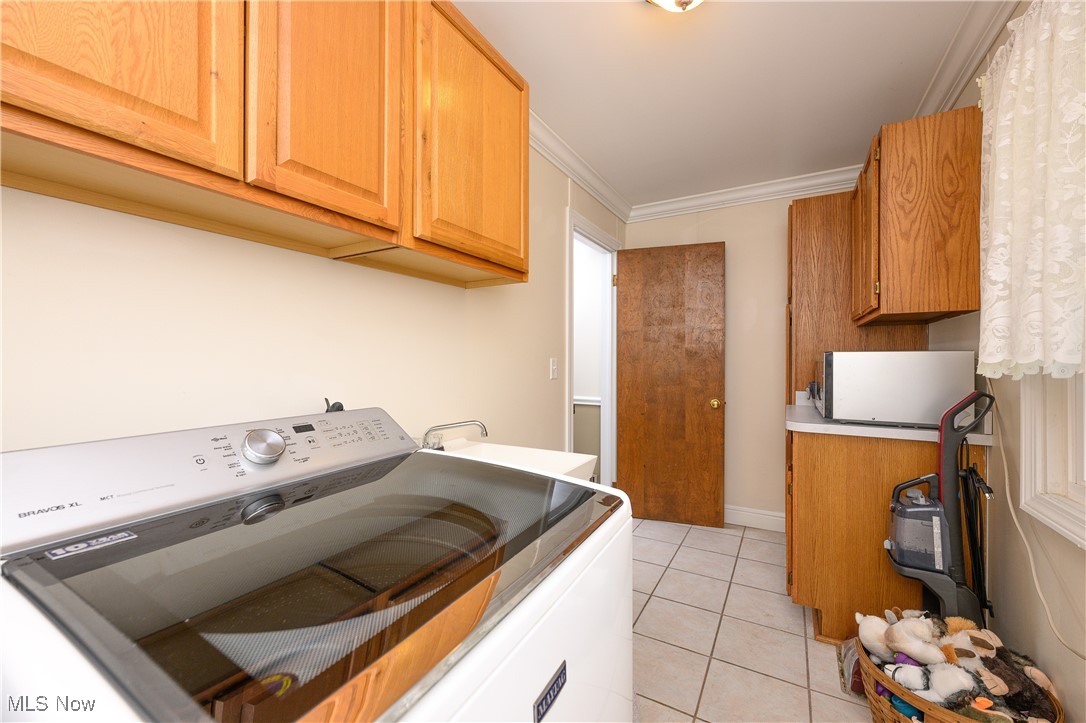 1320 Perry Drive Northwest Canton, OH 44708 - Photo 13 of 34 Laundry room with light tile patterned floors, washer / clothes dryer, sink, crown molding, and cabinets