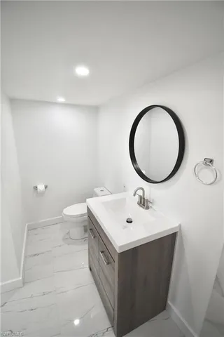a bathroom with a sink mirror and a toilet