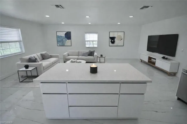 a living room with furniture a flat screen tv and a window