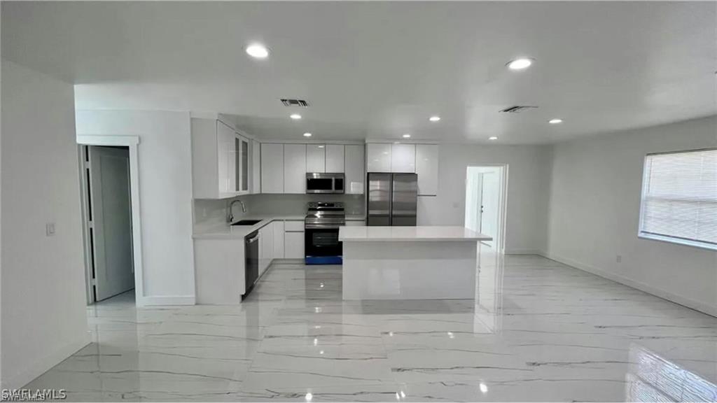 2116 Pineview Road Fort Myers, FL 33901 - Photo 5 of 25 a large kitchen with stainless steel appliances kitchen island granite countertop a refrigerator and a sink