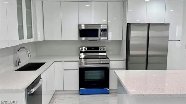 a kitchen with granite countertop a stove and a refrigerator