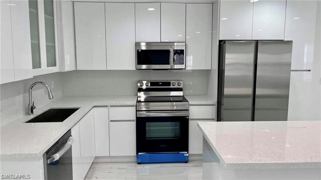 2116 Pineview Road Fort Myers, FL 33901 - Photo 6 of 25 a kitchen with granite countertop a stove and a refrigerator
