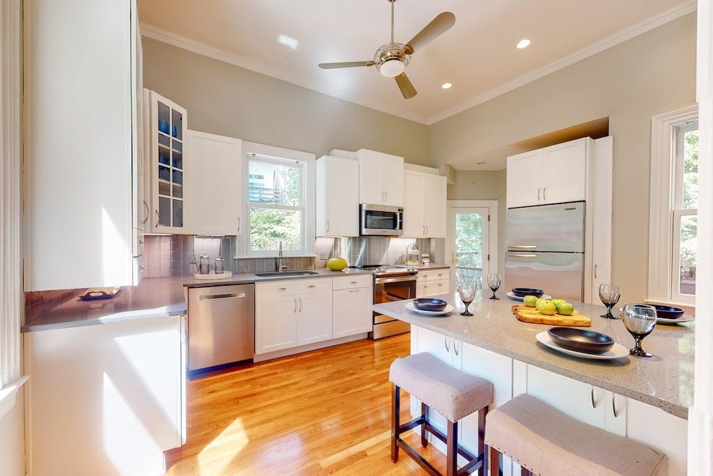 27 Inman Street Cambridge, MA 02139 - Photo 9 of 32 a kitchen with stainless steel appliances granite countertop a stove top oven a sink dishwasher a dining table and chairs with wooden floor