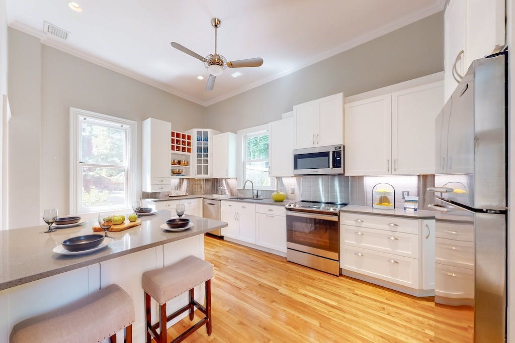 27 Inman Street Cambridge, MA 02139 - Photo 10 of 32 a kitchen with stainless steel appliances granite countertop a stove top oven a sink dishwasher and white cabinets with wooden floor