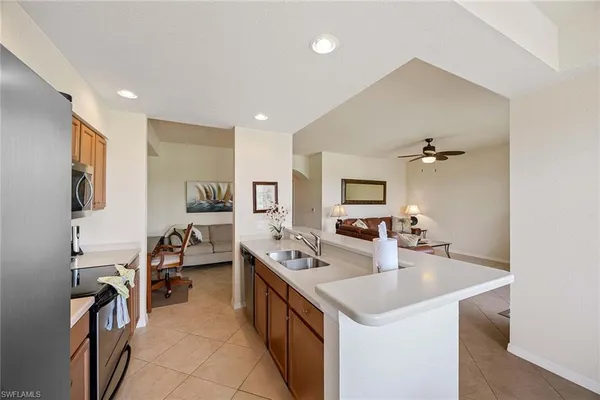 a kitchen with a sink stove and chairs