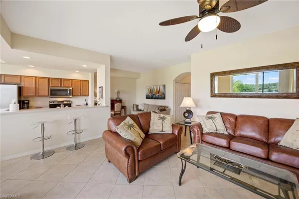 a living room with furniture kitchen view and a window