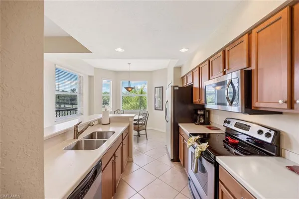 a kitchen that has a sink a stove and a refrigerator