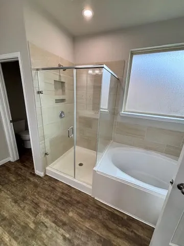 an empty room with windows and ceiling fan