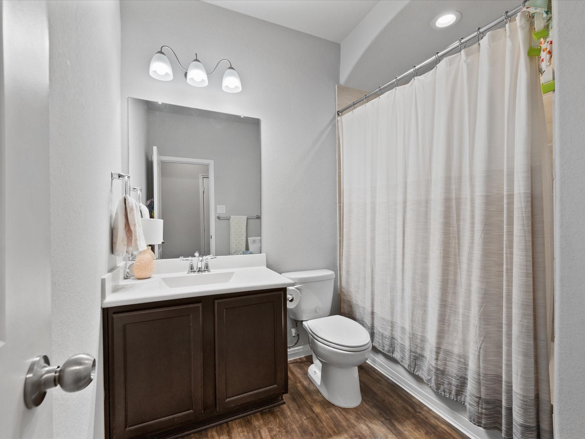 14381 Whitetop Peak Court Conroe, TX 77384 - Photo 19 of 39 a bathroom with a toilet sink and mirror